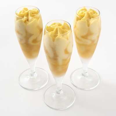 Gelato al mango con variegatura al frutto della passione. Servito in flute in vetro.
